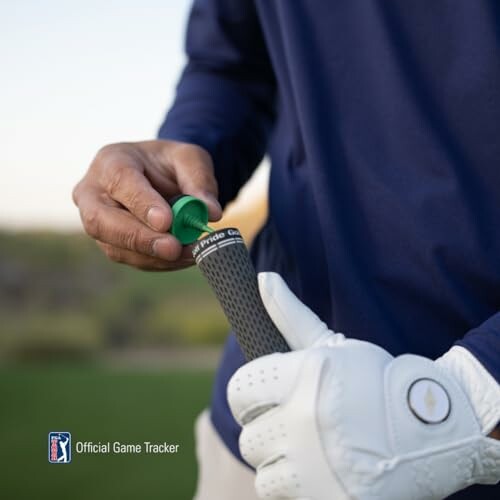 Golfer adjusting grip on club with tee, wearing gloves.